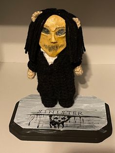 a crocheted doll with dreadlocks and a yellow mask on it's head