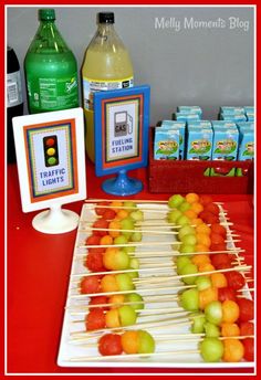 apples and oranges are on skewers with water bottles in the back ground