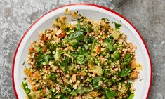 a white plate topped with green vegetables and grains