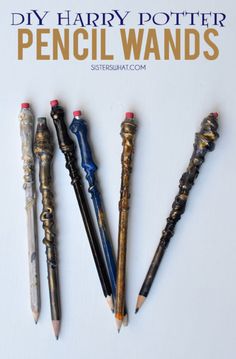 five different types of pens lined up on a white surface with writing utensils