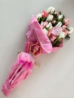 pink and white flowers are in a bouquet on the floor next to a small figure