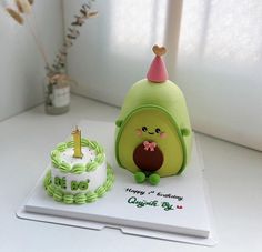 an avocado themed birthday cake next to a happy 1st birthday cupcake