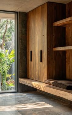 an empty room with wooden shelves and sliding glass doors that lead out to the outside