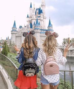 two girls with backpacks are looking at the castle