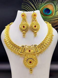 Enhance your bridal look with this exquisite gold-plated jewelry set, featuring a stunning necklace and matching earrings adorned with intricate detailing and vibrant ruby accents. Perfect for weddings, traditional ceremonies, or as a luxurious gift. The necklace boasts an elegant design with a total weight of 82.94 grams, making it both beautiful and durable. This set is a must-have for any bride or jewelry enthusiast looking for timeless elegance and superior craftsmanship. Pack of set- 1 Shor 22k Gold Necklace, Fancy Design, Bridal Jewelry Set, Gold Jewellery Design Necklaces, Gold Work, Work Jewelry, Exclusive Jewelry, Jewelry Design Necklace