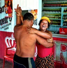 a man and woman dancing in front of a soda shop with their arms around each other