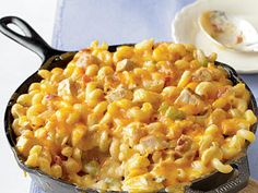 a skillet filled with macaroni and cheese on top of a blue napkin