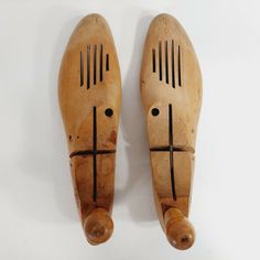 two carved wooden shoes with crosses on the front and back sides, one is made out of wood