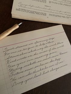 two old papers with writing on them next to a pen