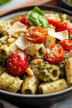 pasta with pesto, tomatoes and pine nuts in a bowl