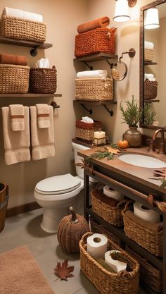 a bathroom with lots of towels and baskets on the shelves above the toilet, along with other items