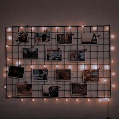 a wall mounted with pictures and lights in the shape of a grid on top of it