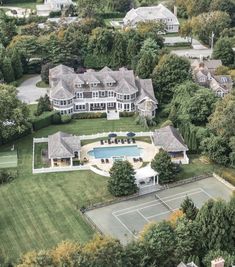 an aerial view of a large house with a tennis court in the middle of it