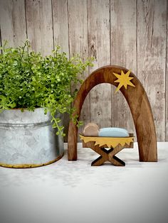 a potted plant sitting on top of a wooden stand next to a small bed