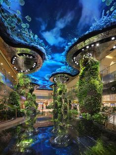 the inside of a shopping mall with plants growing on it's walls and ceiling