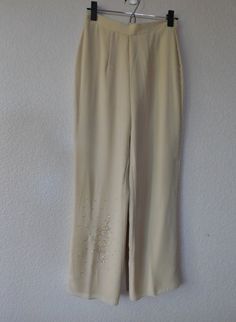 "Elegant vintage pants suit in cream color Simple design/minimalist Floral pattern with beads on front left shoulder and right bottom side of pants Top side slits Pants lined, back zipper Material - 100% polyester Right side pant has a pulled thread at ankle as shown in the photos. When worn, tunic top covers it. Otherwise, condition is great. Dimension Top - shoulder 15.5\" bust 40\" sleeve 23\" length 32\" Pants - waist 13.5\" rise 13\" inseam 28\" out seam 40\" hemline 9.5\"" Beige Pants For Spring Evening, Embellished Bottoms For Formal Spring Events, Elegant Embellished Pants For Spring, Elegant Embellished Summer Pants, Cream Bottoms For Spring Evening, Beaded Pants, Cotton Lace Tops, Sheer Pants, Side Pants