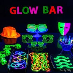 glow party supplies including neon glasses, masks and bracelets on a black table with the words glow bar