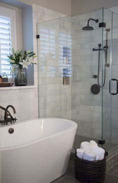 a white bath tub sitting next to a walk in shower