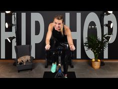 a woman on a stationary bike in front of a shop sign