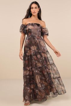 a woman wearing a long dress with floral print on the bottom and off the shoulder