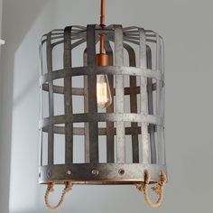 a light fixture made out of metal and rope hanging from the ceiling in a room