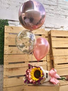 some balloons and flowers are hanging from a wooden pallet