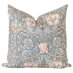 a blue and pink pillow with floral designs on it's sides, sitting against a white background