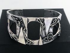 "Artisan Hand Made Sterling Silver Brutalist Cutout Cuff. Unique mix of polished and oxidized sterling silver accented with geometric and free form patterns. Lightly cleaned ready to wear. Will Fit Wrists Up To 6 3/4\" Markings: Unmarked, Acid tested and sterling silver. Measurements: Approx 6 3/4 inch total inside circumference including wrist opening, 2 3/8 inch inside diameter, 1 1/8 inch wrist opening and 1 3/4\" wide at front center. Total Weight: 40.5 grams Condition: Good Vintage Conditio Unique Oxidized Finish Cuff Bangle, Unique Oxidized Cuff Bracelet Bangle, Artistic Silver Cuff Bracelet, Unique Oxidized Finish Cuff Bracelet For Gift, Unique Oxidized Finish Cuff Bracelet As Gift, Unique Cuff Bracelet With Oxidized Finish As Gift, Unique Silver Cuff Bracelet With Oxidized Finish, Modern Oxidized Finish Cuff Bracelet, Modern Oxidized Finish Cuff Bangle Bracelet