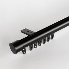 a black metal rail with holes in the middle on a white surface, and one section is missing