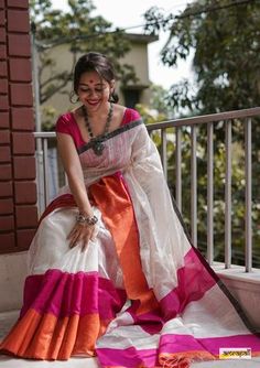 a woman is sitting on the steps in a colorful sari and smiling for the camera