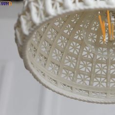 a white chandelier hanging from the ceiling with two yellow candles in front of it