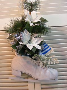 a pair of ice skates decorated with flowers and greenery sitting on a window sill