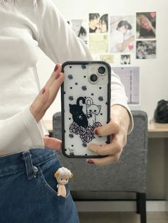 a woman is holding up her phone case to show it's cartoon character design