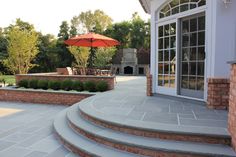 a patio with steps and an umbrella over it