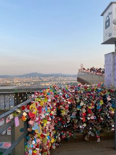 a large amount of love locks attached to the side of a building with buildings in the background