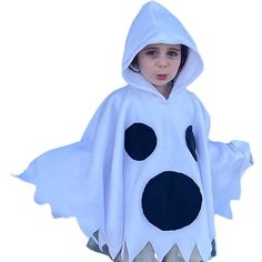 a young boy dressed in a white ghost costume with black polka dots on his face