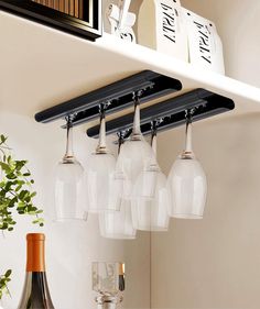 there are six wine glasses hanging from the shelf above the bar and on the wall