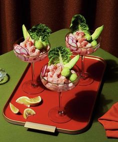 three glasses filled with food sitting on top of a red tray