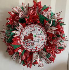 a red and white christmas wreath with an image of santa claus on the front door