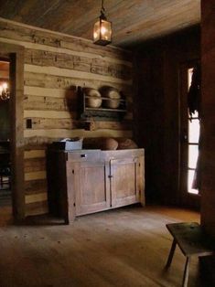 an old fashioned kitchen with wood paneling and lights hanging from the ceiling above it