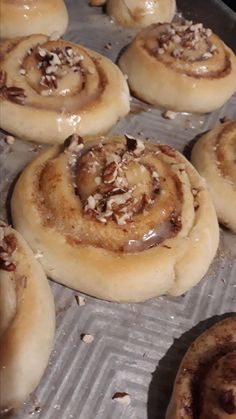 some cinnamon rolls are sitting on a baking sheet