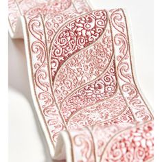 a red and white paisley print tie on a white tablecloth with an intricate design