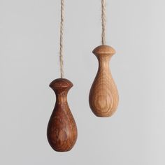 two wooden ornaments hanging from twine strings