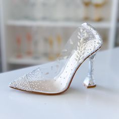 a pair of white high heeled shoes sitting on top of a table