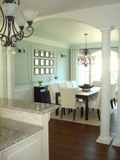 a dining room and kitchen area with marble counter tops, chandelier, and wood flooring