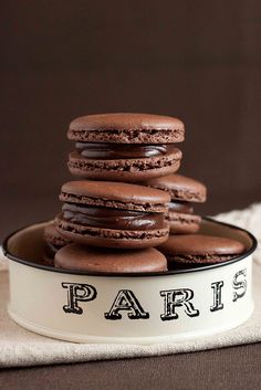 chocolate cookies stacked on top of each other in a white bowl with paris written across the bottom