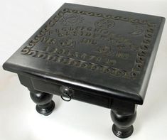 a small black table sitting on top of a white surface