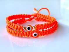 "Orange evil eye with neon orange braided macramé bracelet and accented with gold-filled beads in sizes for women's men and kids, Custom-made to your own wrist size, Bracelet is safe to get wet, Bracelet is 5mm wide and Eye bead is 8.5 mm A pretty bright orange color string with a glass orange evil eye amulet for a little more protection and good luck 𝗛𝗮𝗻𝗱𝗺𝗮𝗱𝗲 𝗴𝗶𝗳𝘁  A lovely Handmade-orange-jewelry-gift for you and loved ones  Custom made by hand with Love and care in our workshop Re Orange Evil Eye Bracelet, Handmade Orange Spiritual Bracelets, Handmade Adjustable Orange Bracelets, Adjustable Handmade Orange Bracelets, Adjustable Handmade Orange Bracelet, Handmade Orange Bracelets For Festival, Orange Bohemian Friendship Bracelets As Gifts, Orange Bohemian Friendship Bracelets Gift, Bohemian Orange Friendship Bracelets For Gift