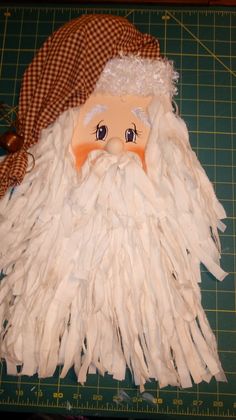 a close up of a fake santa clause on a cutting board with scissors and tape