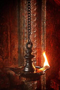 an oil lamp is lit in the dark with red light coming from it's side